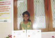 Dilhani im Chathura-Kinderheim freut sich ueber die Urkunden fuer gute Schulleistungen 