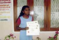 Nadika im Chathura-Kinderheim freut sich ueber die Urkunden fuer gute Schulleistungen 