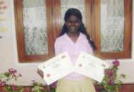 Renuka im Chathura-Kinderheim freut sich ueber die Urkunden fuer gute Schulleistungen