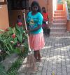 Ein Mädchen fegt den Hof beim Chathura-Kinderheim 